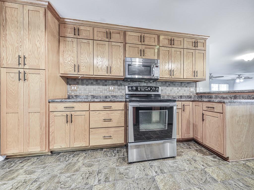 424 Shamrock Drive Dalton, GA 30721 - Photo 3 of 38 a kitchen with granite countertop a stove top oven microwave and cabinets
