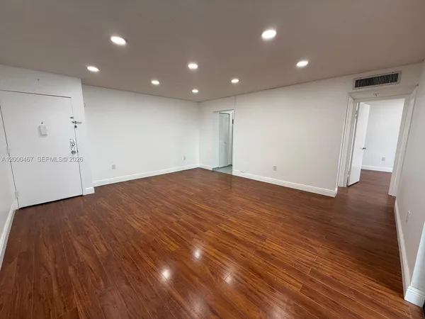 a view of empty room with wooden floor