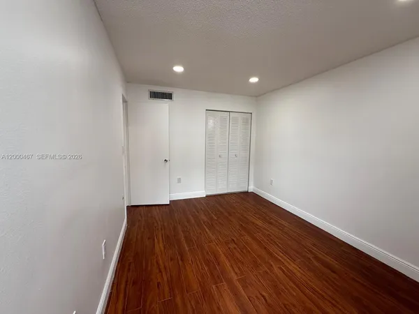 a view of empty room with wooden floor