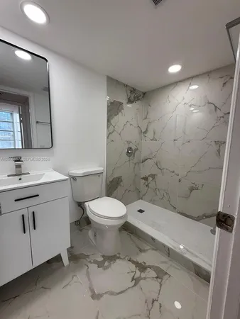 a bathroom with a toilet sink vanity and mirror