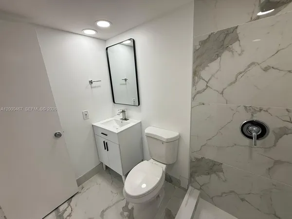 a bathroom with a toilet sink and mirror
