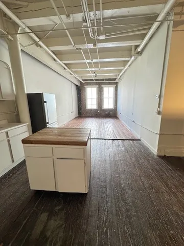 en empty room with wooden floor and fan