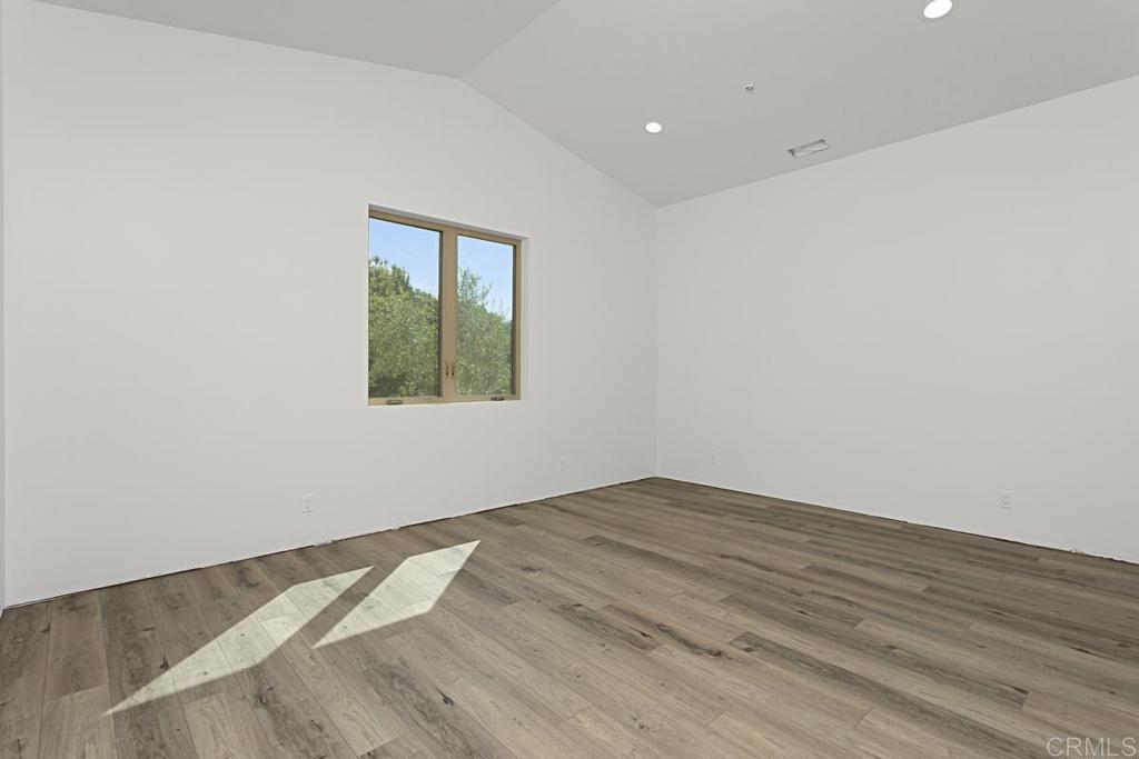 5808 Lake Vista Drive Bonsall, CA 92003 - Photo 17 of 40 an empty room with wooden floor and windows