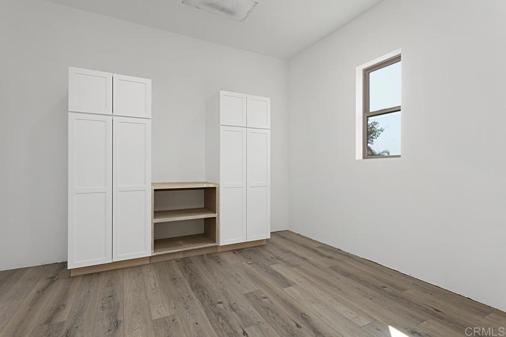 5808 Lake Vista Drive Bonsall, CA 92003 - Photo 21 of 40 an empty room with wooden floor closet and windows