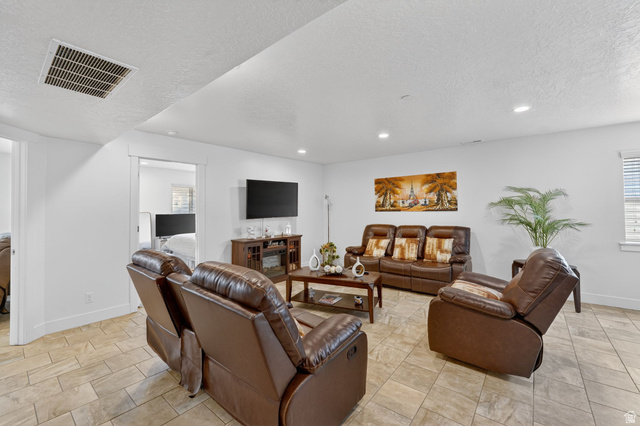 141 Wolverine Creek Elk Ridge, UT 84651 - Photo 22 of 47 Living room featuring a textured ceiling and recessed lighting
