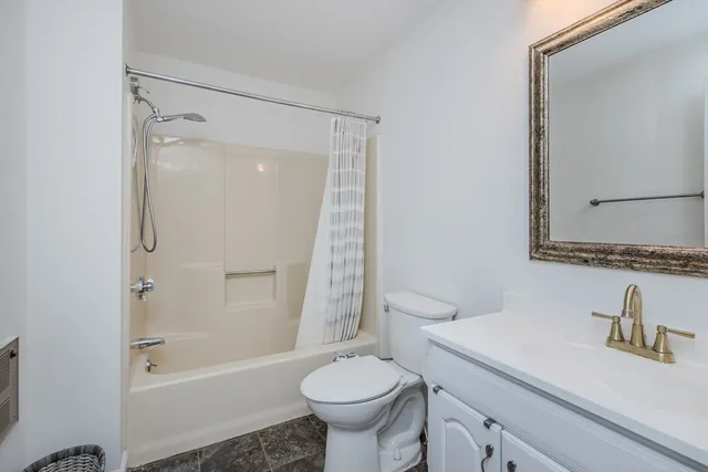 a bathroom with a granite countertop sink toilet and shower