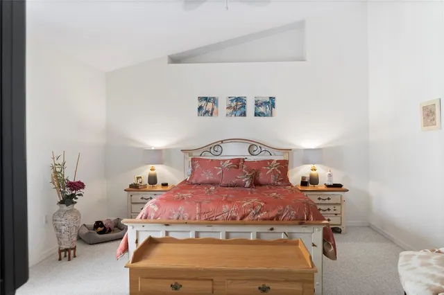 a bedroom with a bed and a flat tv screen on dresser