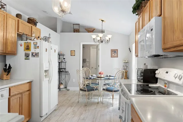 a kitchen with a sink a stove cabinets and wooden floor