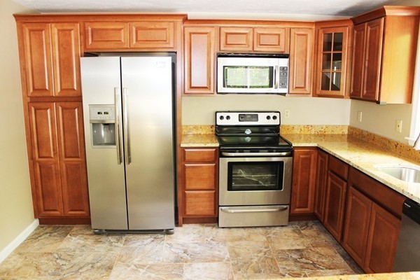 24 Sycamore Drive Rutland, MA 01543 - Photo 11 of 30 a kitchen with stainless steel appliances granite countertop a refrigerator and a stove top oven