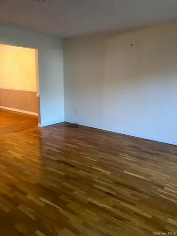 a view of a room with wooden floor a fireplace and chandelier