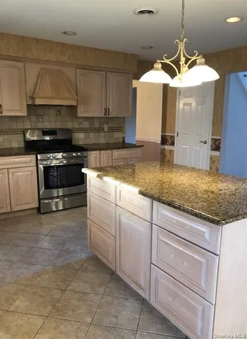 a kitchen with a stove a sink and cabinets