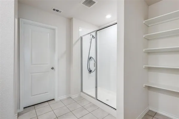 a bathroom with a shower and a glass door