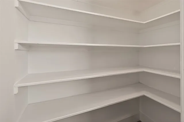 a view of empty room with wooden floor and ceiling fan
