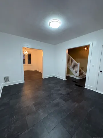 an empty room with windows and fireplace