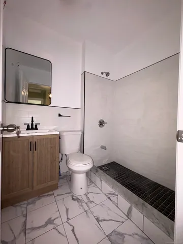 a bathroom with a toilet a sink and mirror