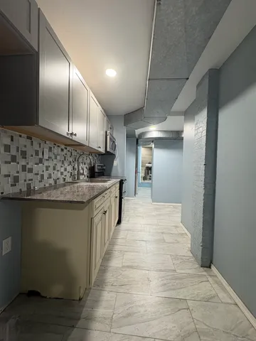 a kitchen with stainless steel appliances kitchen island granite countertop a sink and cabinets