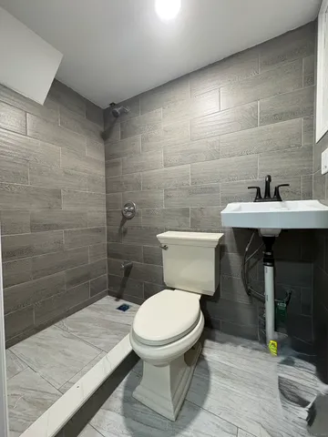 a bathroom with a toilet a sink and mirror