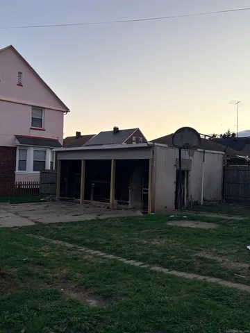 a view of a yard in front of a house with large windows