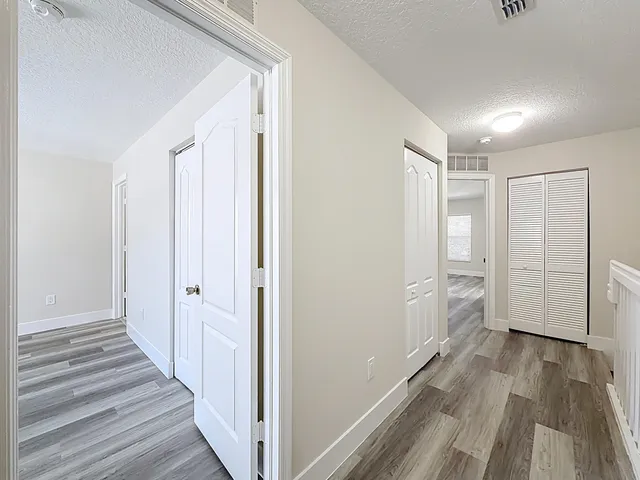 a view of a hallway with wooden floor