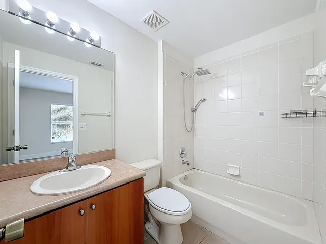 a bathroom with a sink toilet tub vanity and shower
