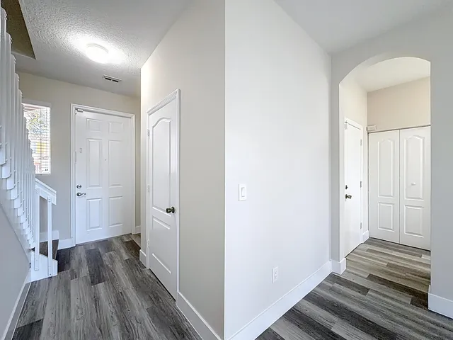 a view of a hallway with wooden floor and staircase