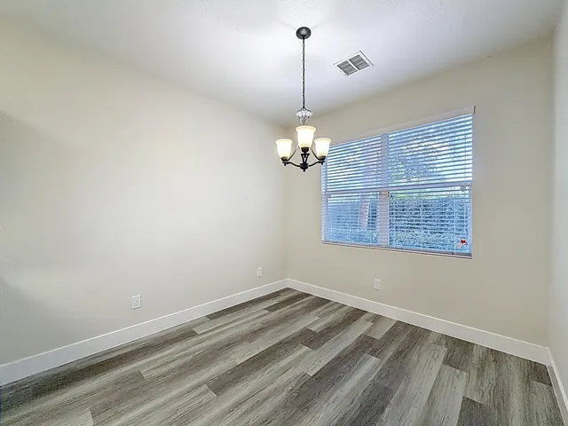 a view of wooden floor and chandelier in a room