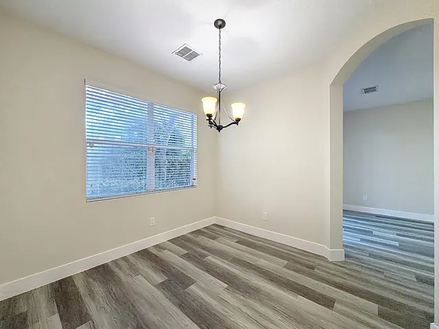a view of a room with wooden floor and chandelier