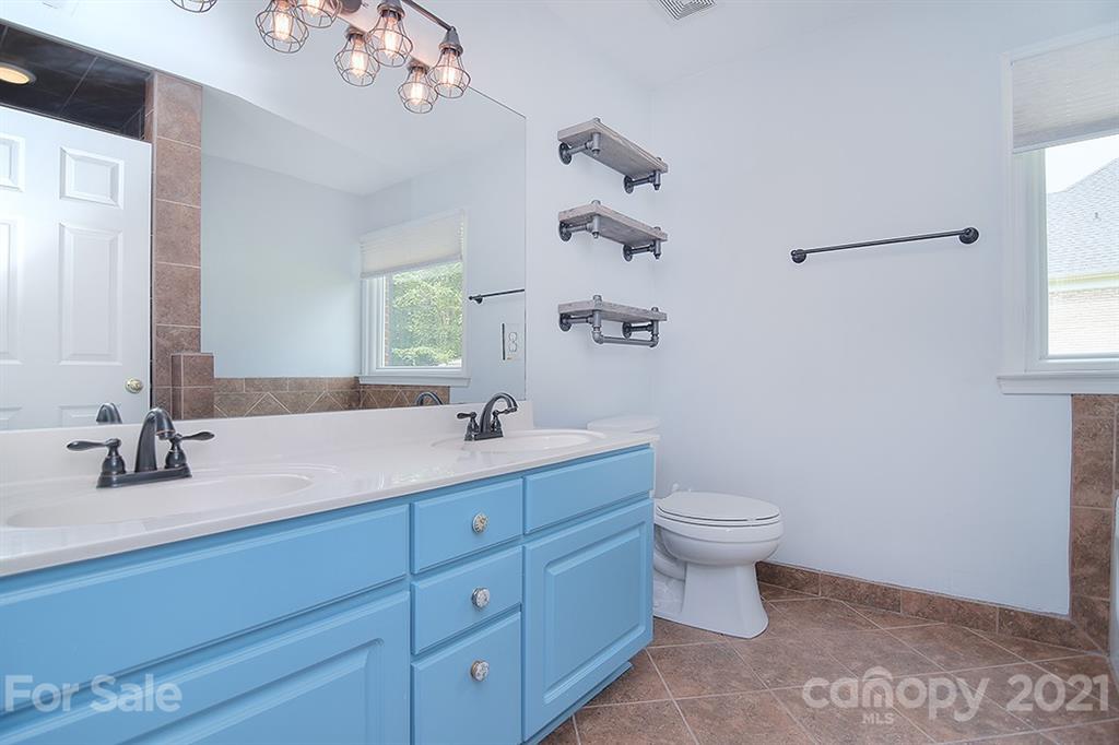 4306 Atkinson Way Monroe, NC 28110 - Photo 24 of 31 a bathroom with a toilet a sink a large mirror and vanity