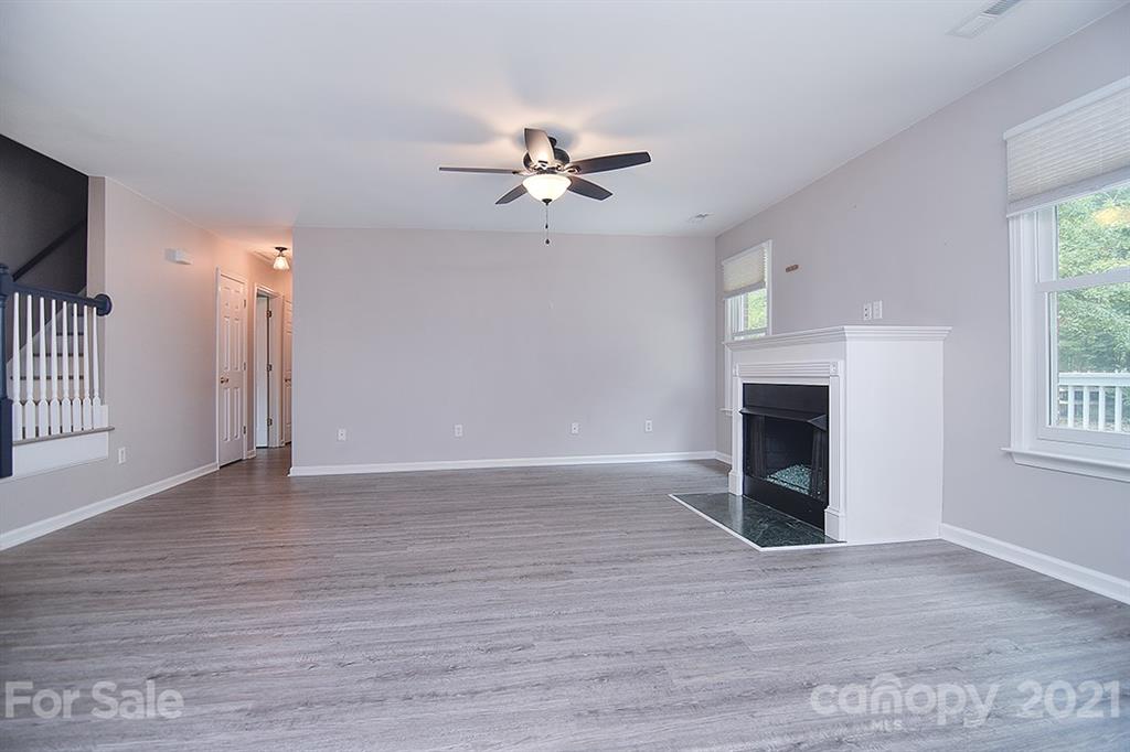 4306 Atkinson Way Monroe, NC 28110 - Photo 4 of 31 wooden floor in an empty room with a fireplace