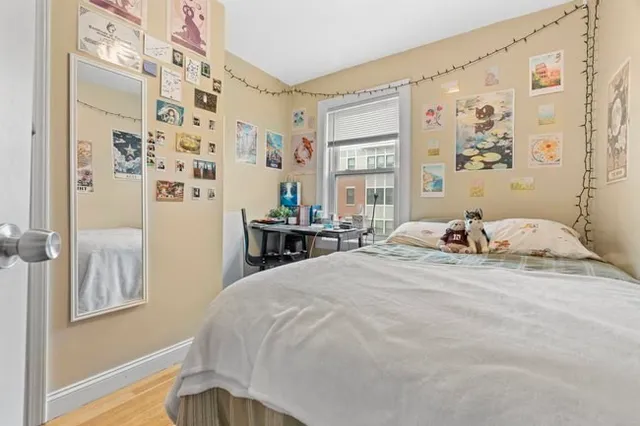 a bedroom with a bed and a window with wooden floor