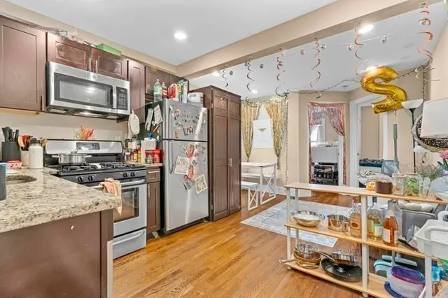 a kitchen with stainless steel appliances granite countertop a stove refrigerator and a microwave