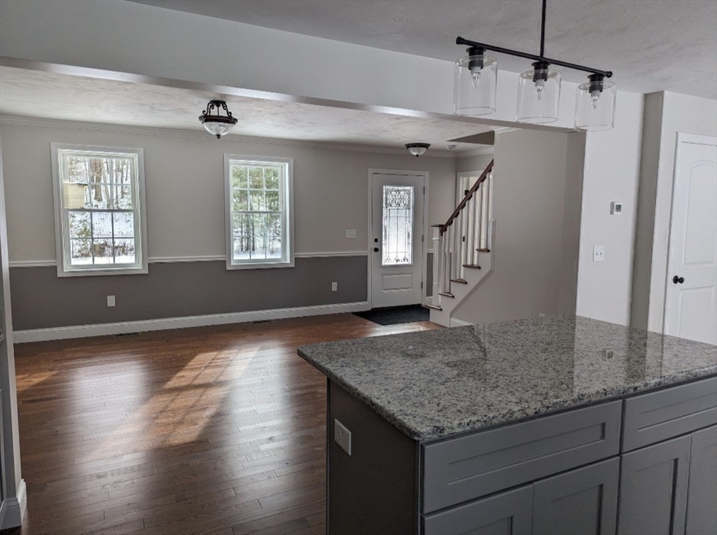 514 Old County Road Holland, MA 01521 - Photo 13 of 40 a kitchen with kitchen island granite countertop a sink cabinets and wooden floor