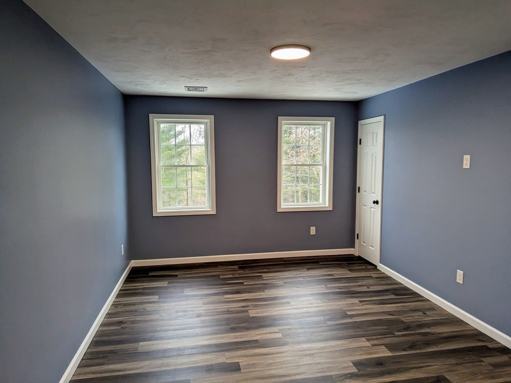 514 Old County Road Holland, MA 01521 - Photo 21 of 40 an empty room with wooden floor and windows