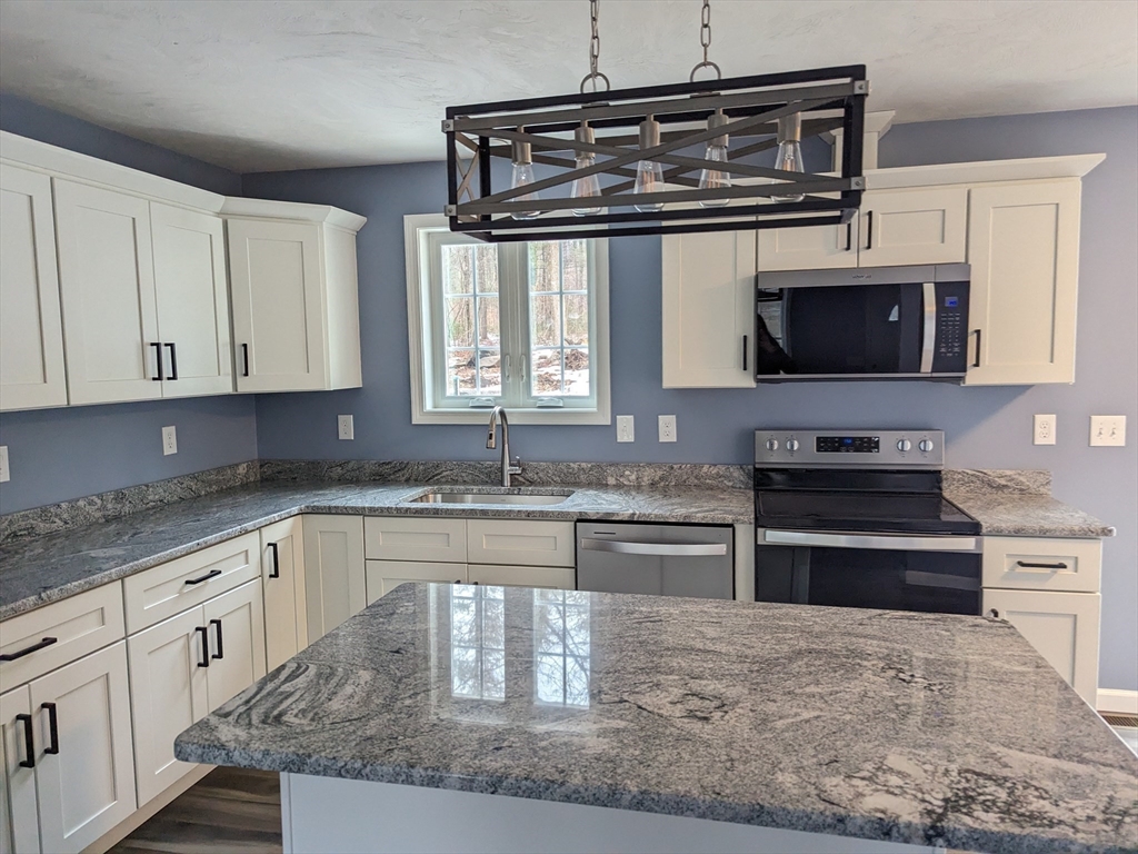 514 Old County Road Holland, MA 01521 - Photo 6 of 40 a kitchen with stainless steel appliances granite countertop a stove and a microwave