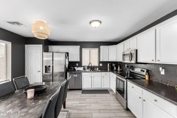 a kitchen with granite countertop a sink stainless steel appliances and cabinets