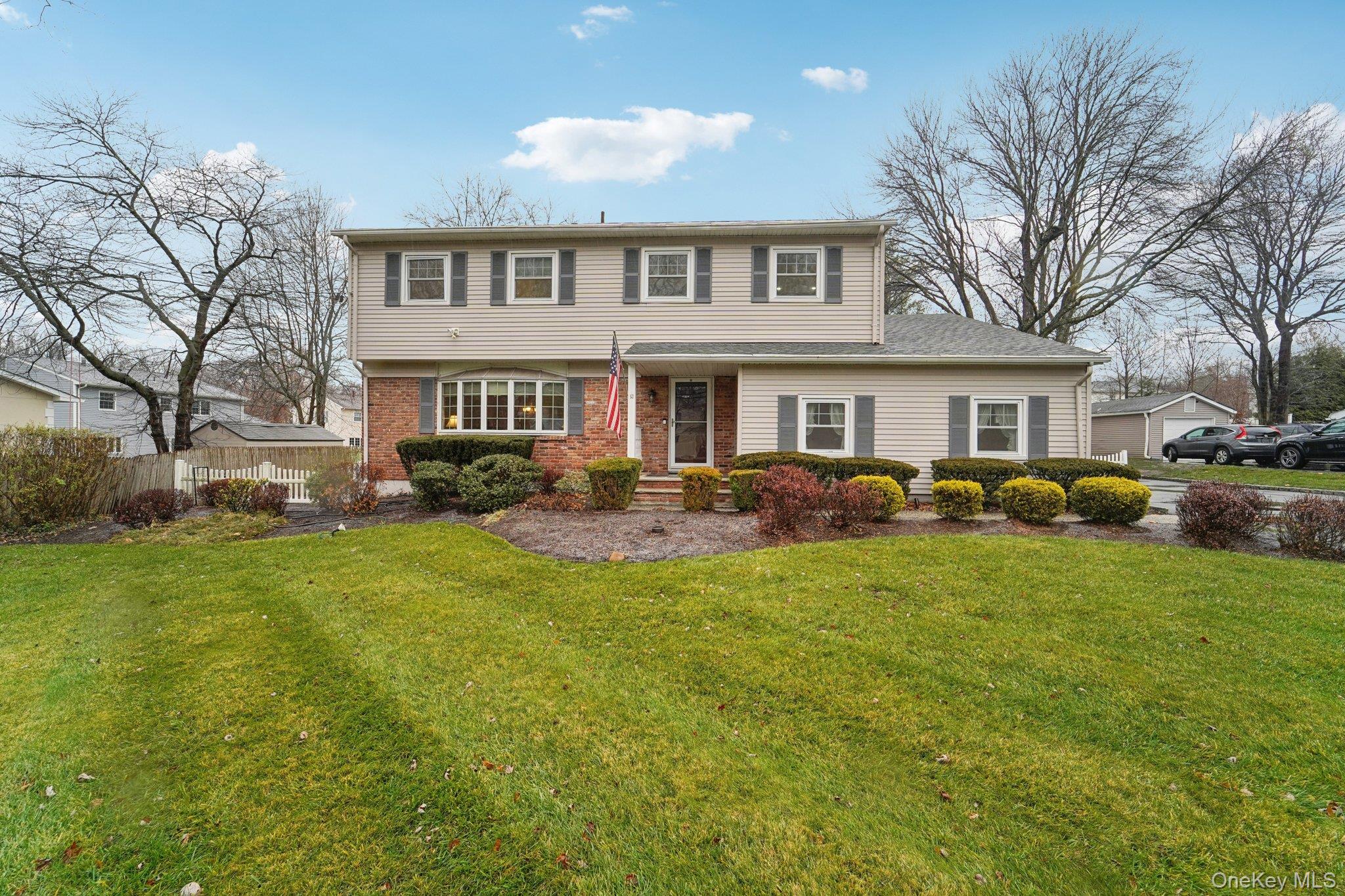 a front view of a house with a yard and trees