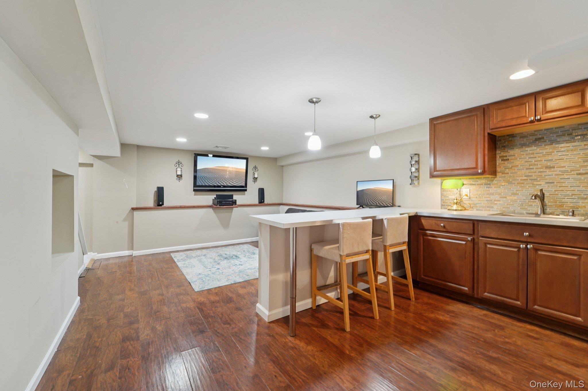 84 Townline Road Nanuet, NY 10954 - Photo 36 of 44 Kitchen with a peninsula, brown cabinetry, recessed lighting, hanging light fixtures, and dark wood-style floors