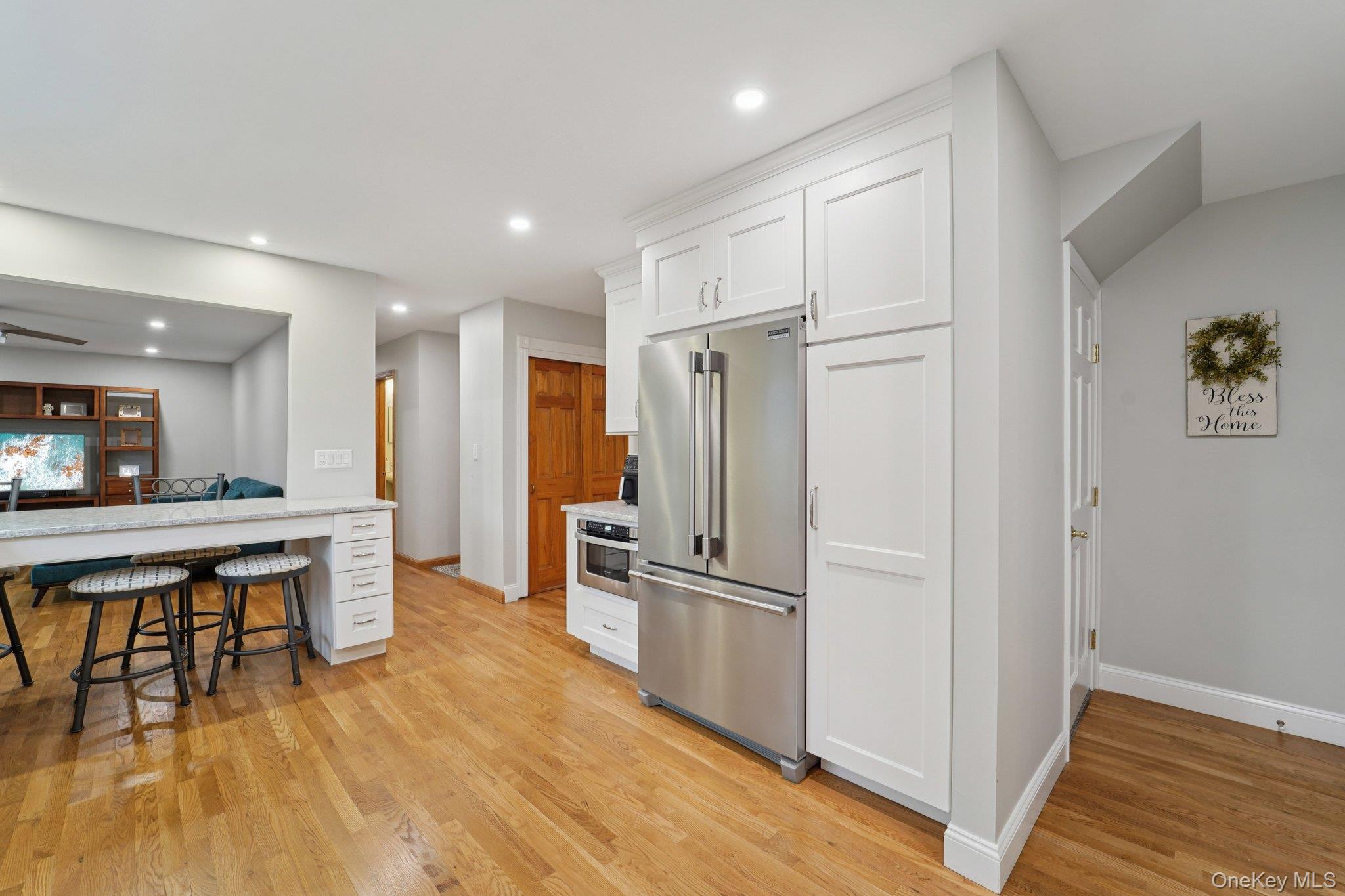 84 Townline Road Nanuet, NY 10954 - Photo 8 of 44 Kitchen with appliances with stainless steel finishes, white cabinetry, a kitchen bar, light wood-style floors, and recessed lighting