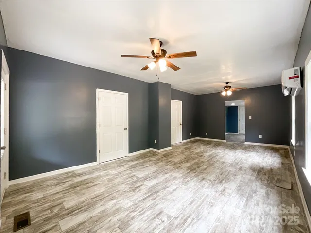 a view of a big room with chandelier fan and windows
