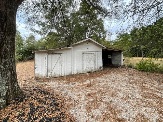 a view of a house with a yard and large tree