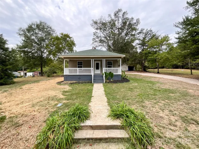 a view of a house with backyard and trees