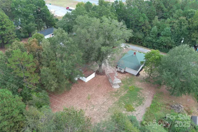 an aerial view of residential house with outdoor space and trees all around