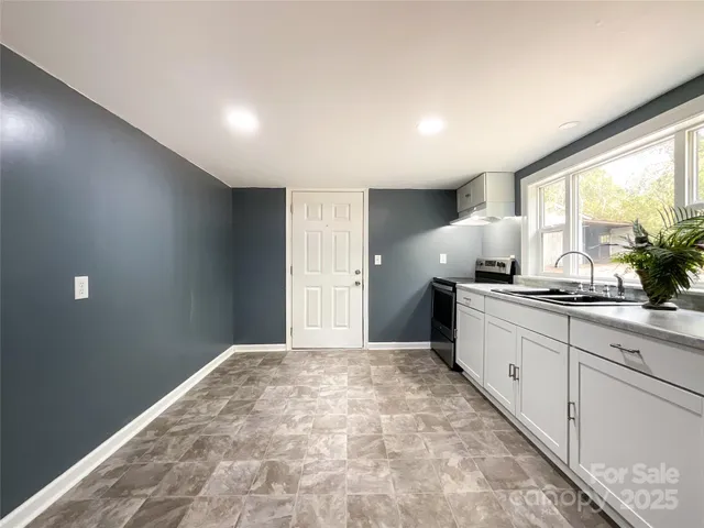 a large white kitchen with a large window