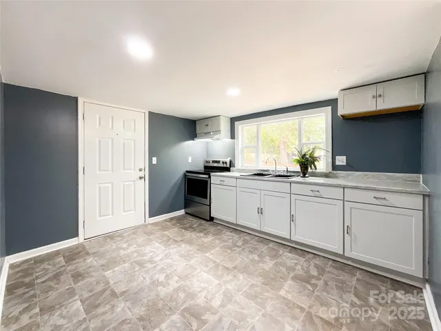 a kitchen with granite countertop a sink and cabinets