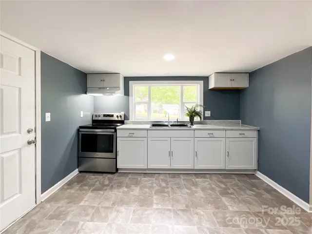 a kitchen with granite countertop a sink cabinets and stainless steel appliances