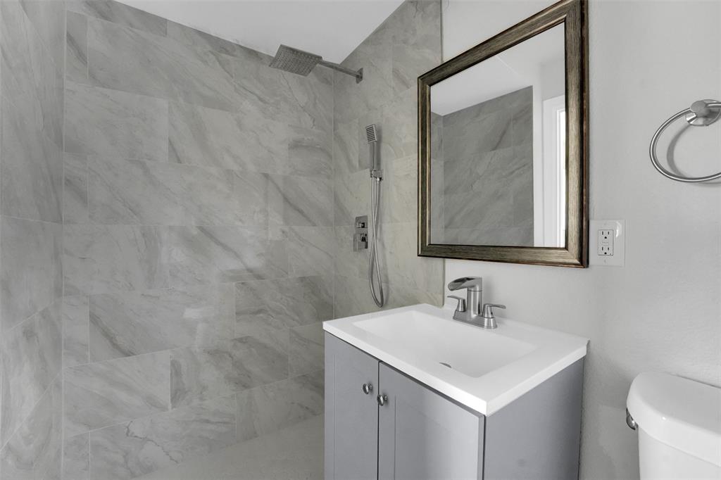 1507 East Lovers Lane Arlington, TX 76010 - Photo 11 of 18 a bathroom with a sink a mirror and a toilet