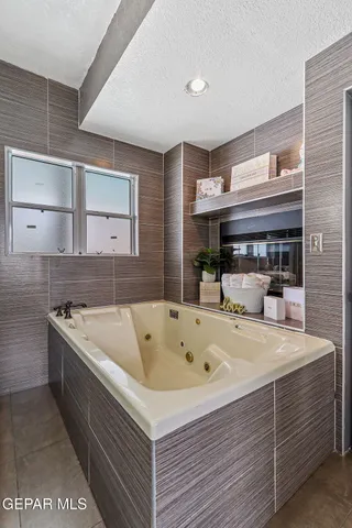 a view of swimming pool with lawn chairs and floor to ceiling window