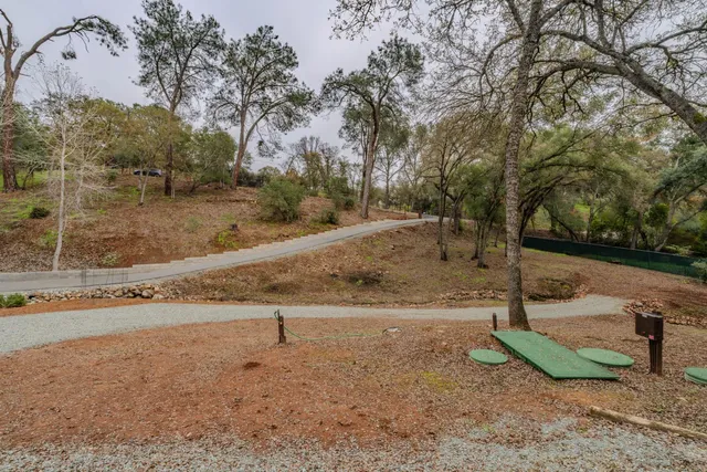 a view of a yard with wooden fence