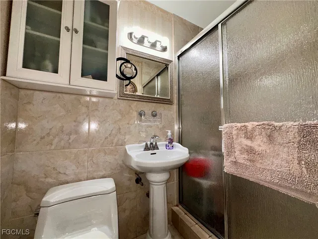 a bathroom with a sink toilet and a mirror