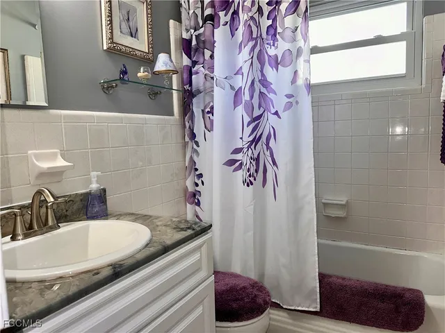 a bathroom with a granite countertop sink a toilet and bathtub